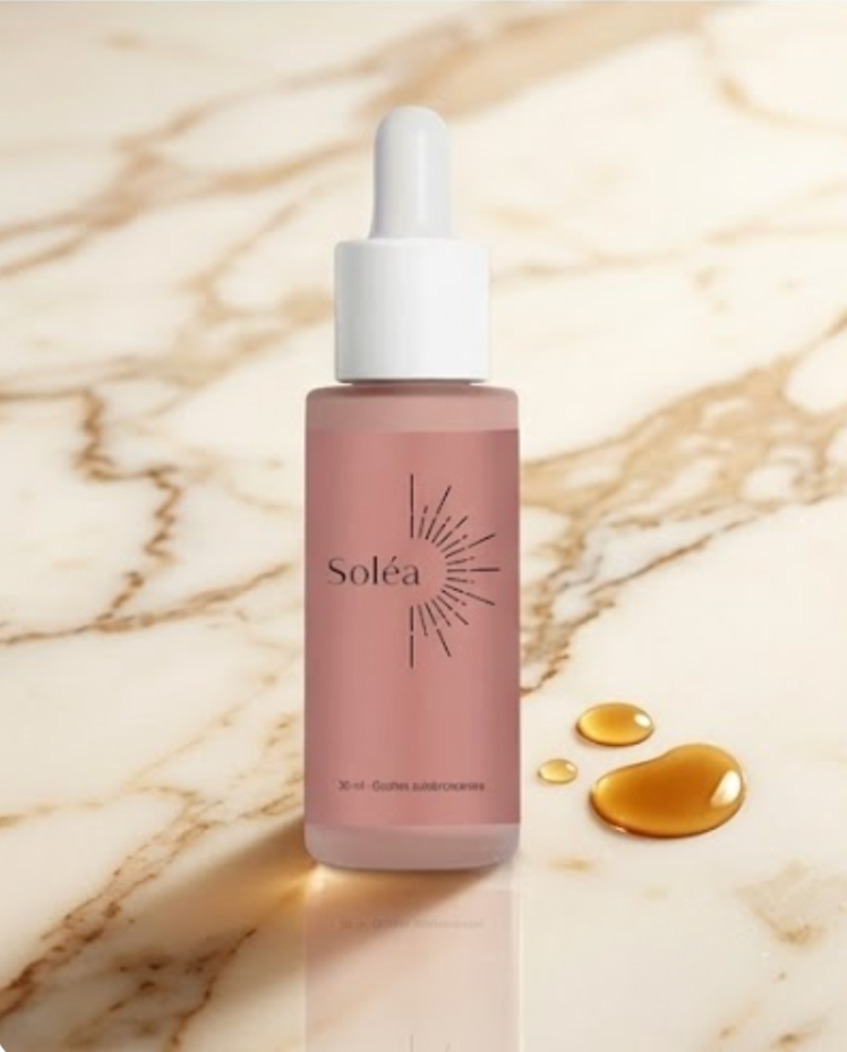 Soléa gouttes autobronzantes – flacon sur marbre, gouttes dorées